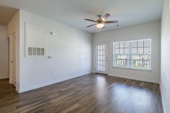 A room with a ceiling fan and a window with blinds.